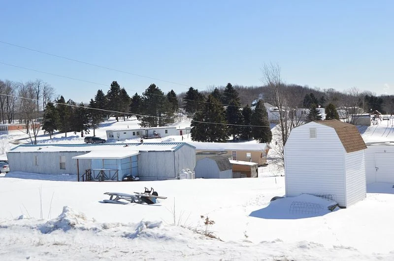 Manufactured homes and a yard covered in snow.