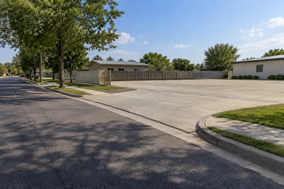 Illustration of a broad curb cut connecting a street to an empty paved yard.